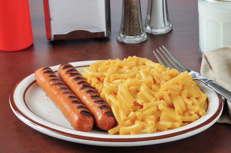 Grilled sausages with macaroni and cheese on plate.