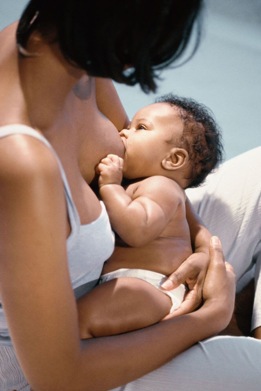 Mother breastfeeding baby in a tender embrace.