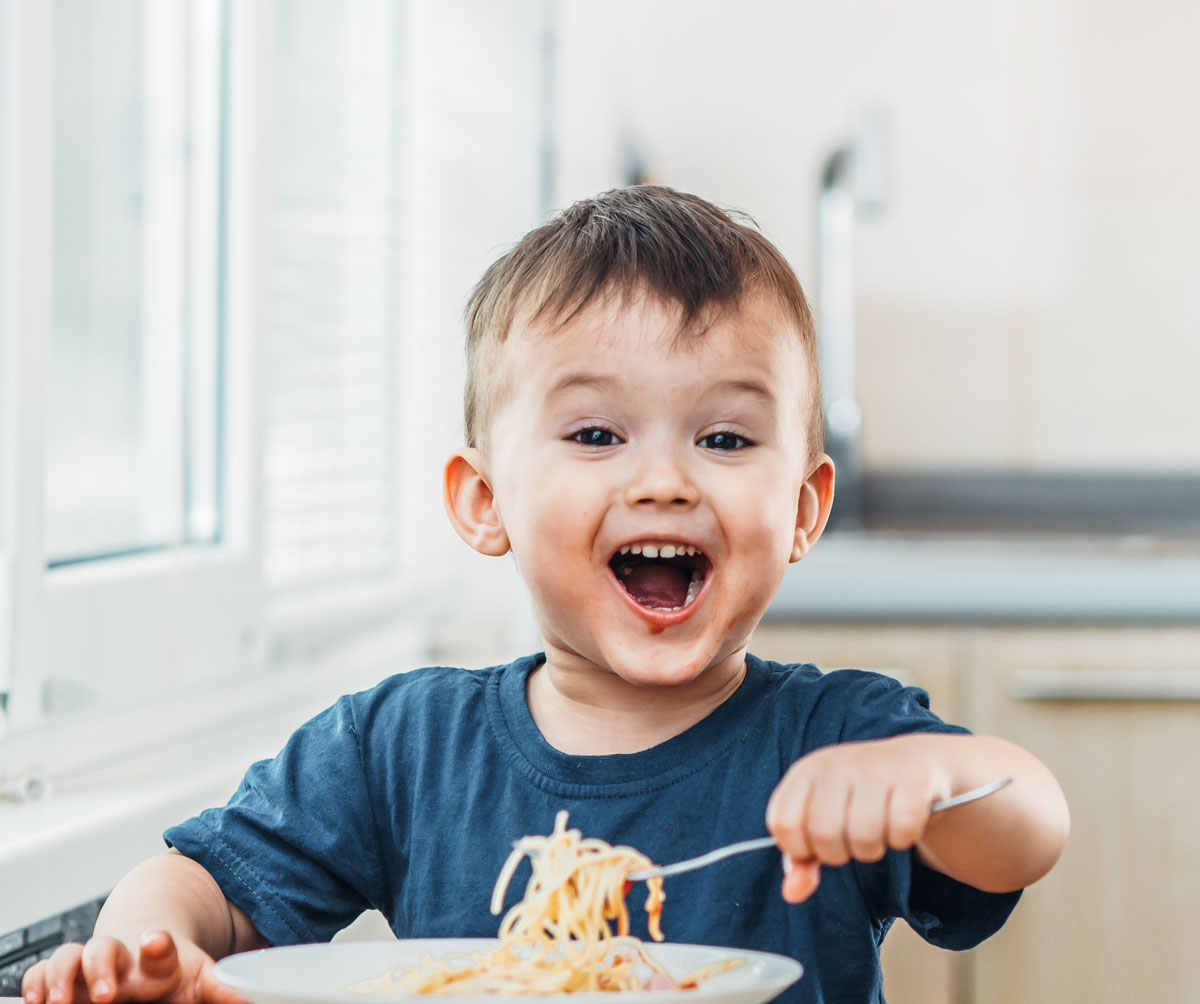 boy eating food with a fork