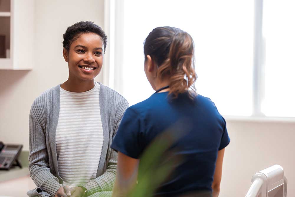 Woman smiling during a consultation with a healthcare professional.