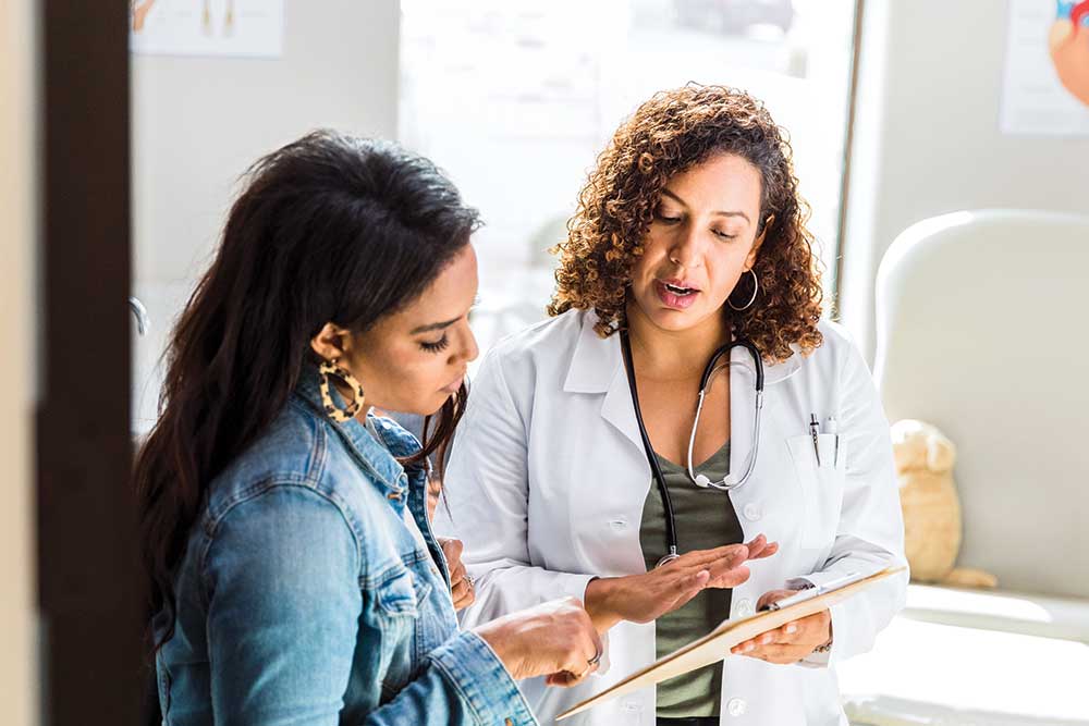 Doctor explains information to a patient with clipboard.