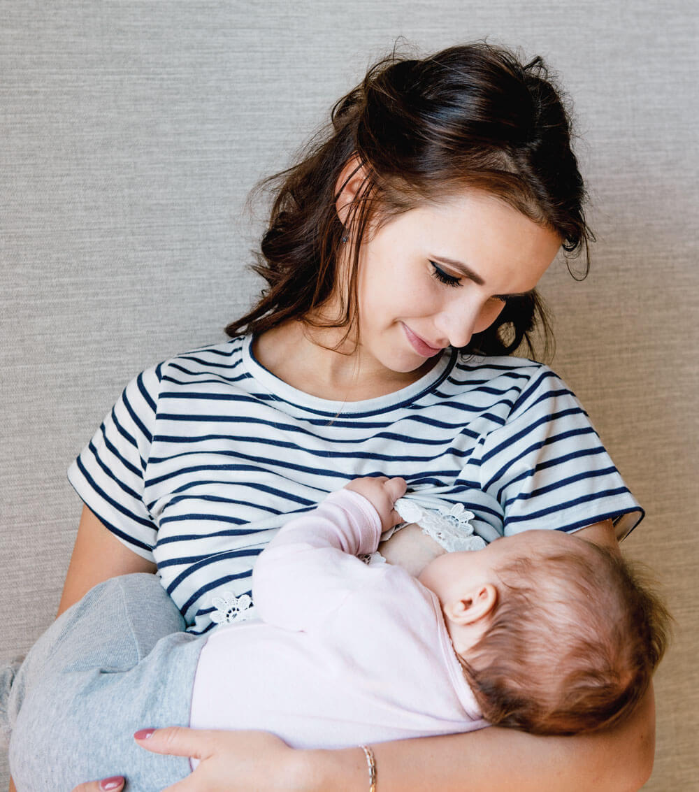 Mother breastfeeding baby, both content and relaxed.