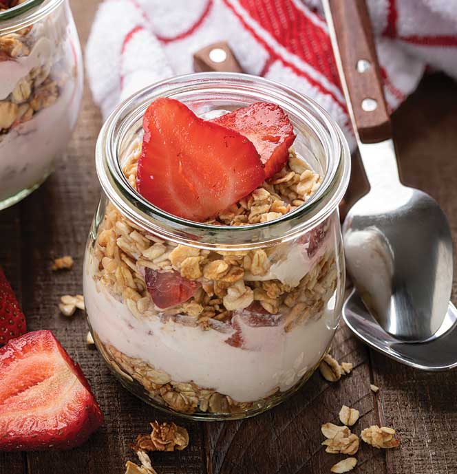 Strawberry yogurt parfait with granola in a jar.