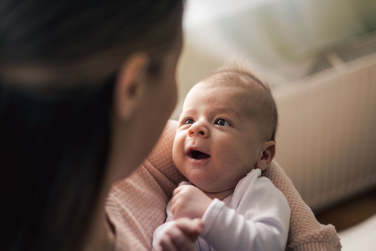 Smiling baby looking up while being held.