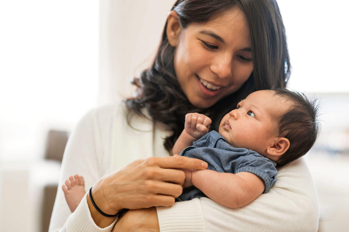 Mother gently cradling her attentive baby.
