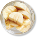 Sliced bananas in a glass bowl, top view.