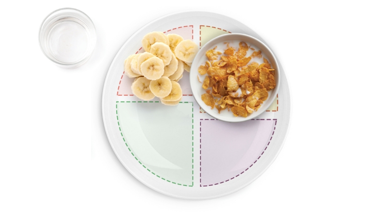 Plate with bananas, cereal; glass of water nearby.