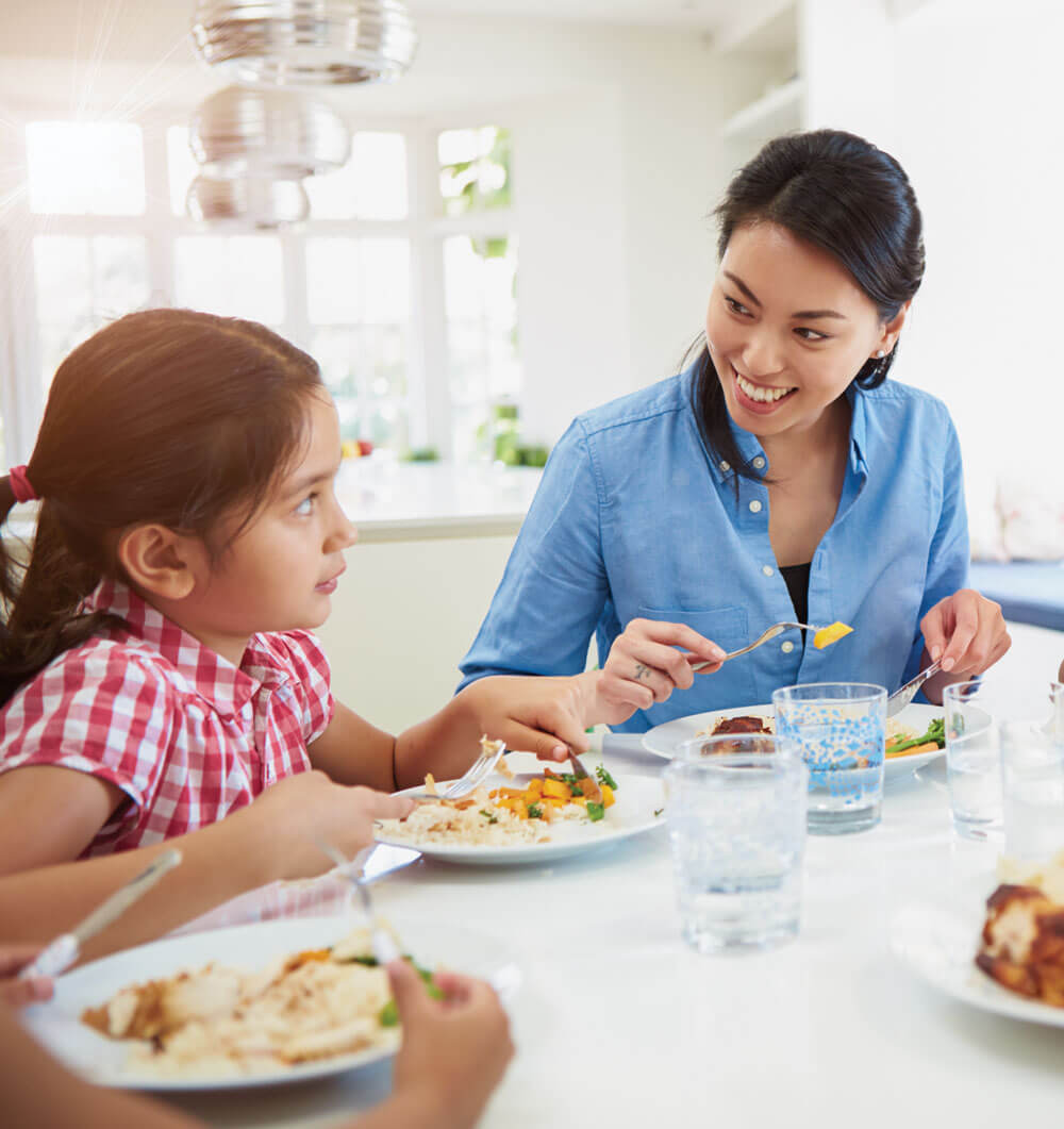 Family enjoying meal together at a bright kitchen.
