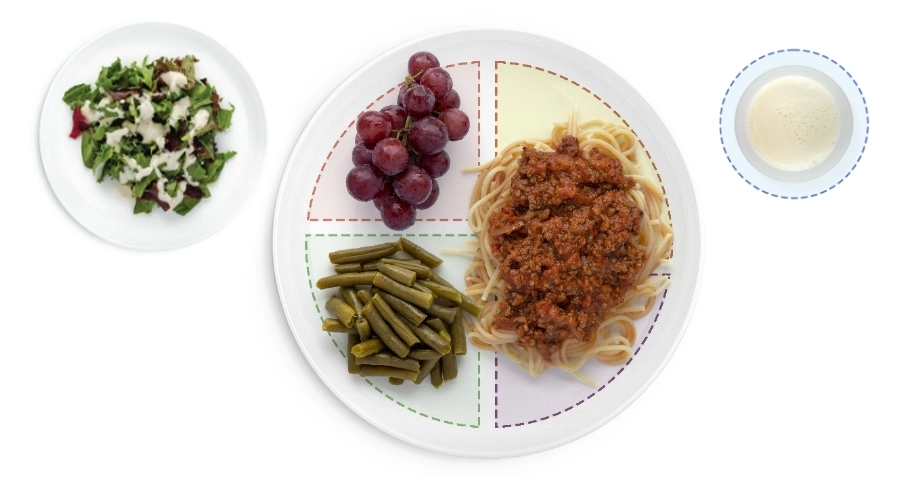 Healthy meal with spaghetti, salad, grapes, green beans.