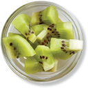 Kiwi slices in a glass bowl, top view.