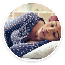 Woman lying down, resting peacefully on a pillow.