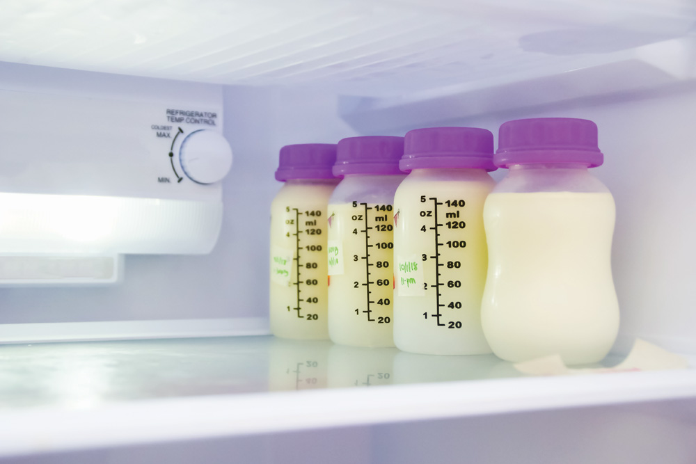Breast milk bottles stored in refrigerator shelf.
