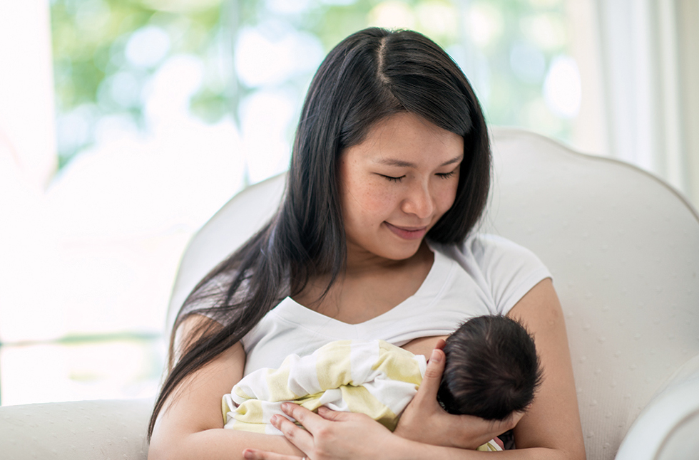 Breastfeeding mother holding baby