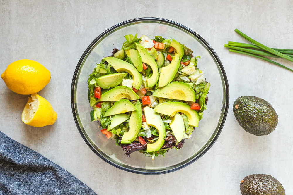 Avocado salad in bowl with lemons and avocados.