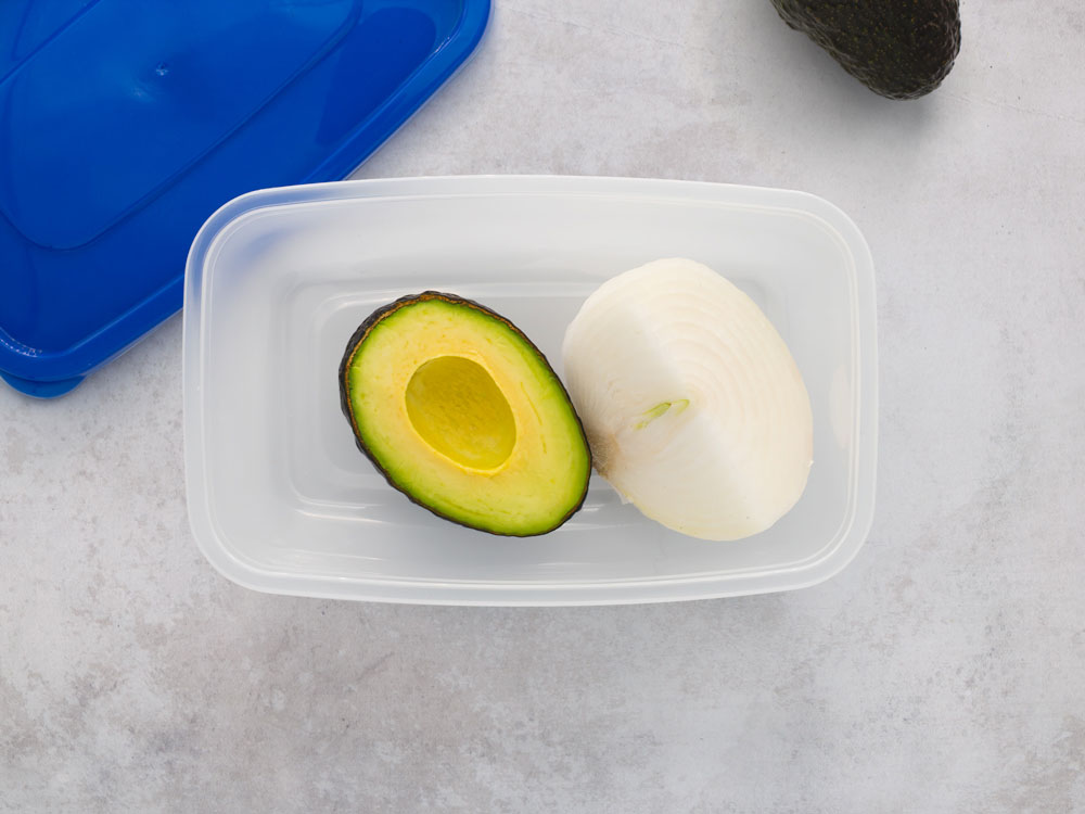 Avocado and onion in a plastic container.