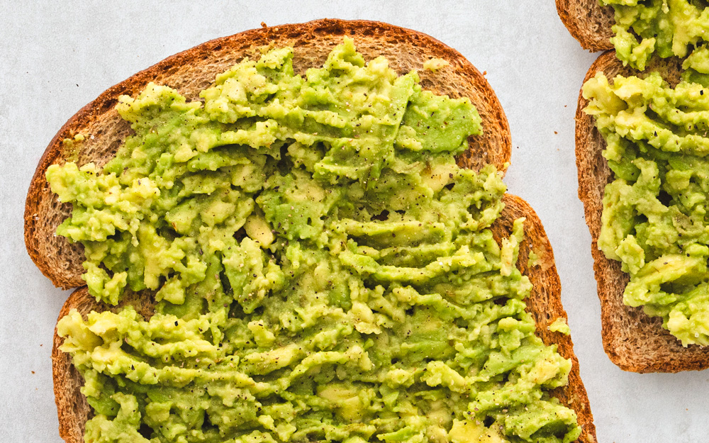Avocado mashed on whole grain toast slices.