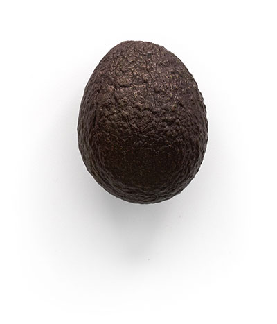 Whole avocado on a plain white background.