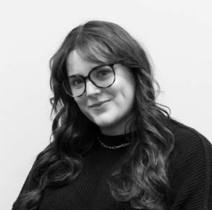 Smiling woman with glasses, wearing a black sweater.