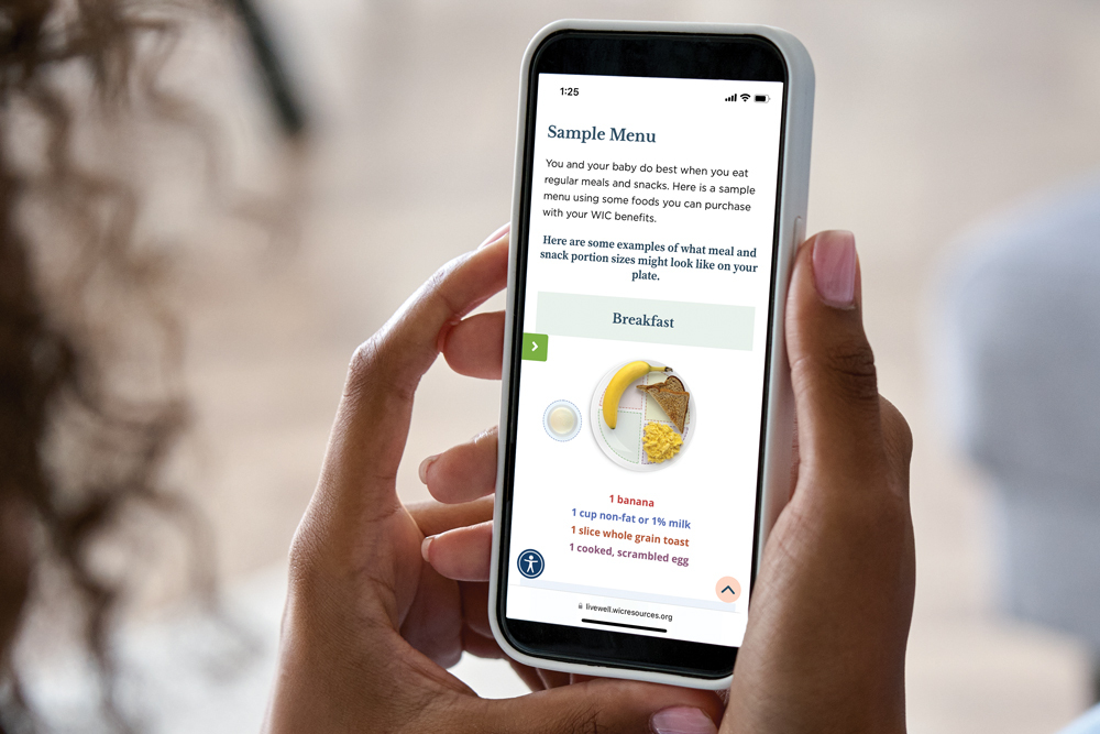 Person holding smartphone with WIC breakfast menu displayed.