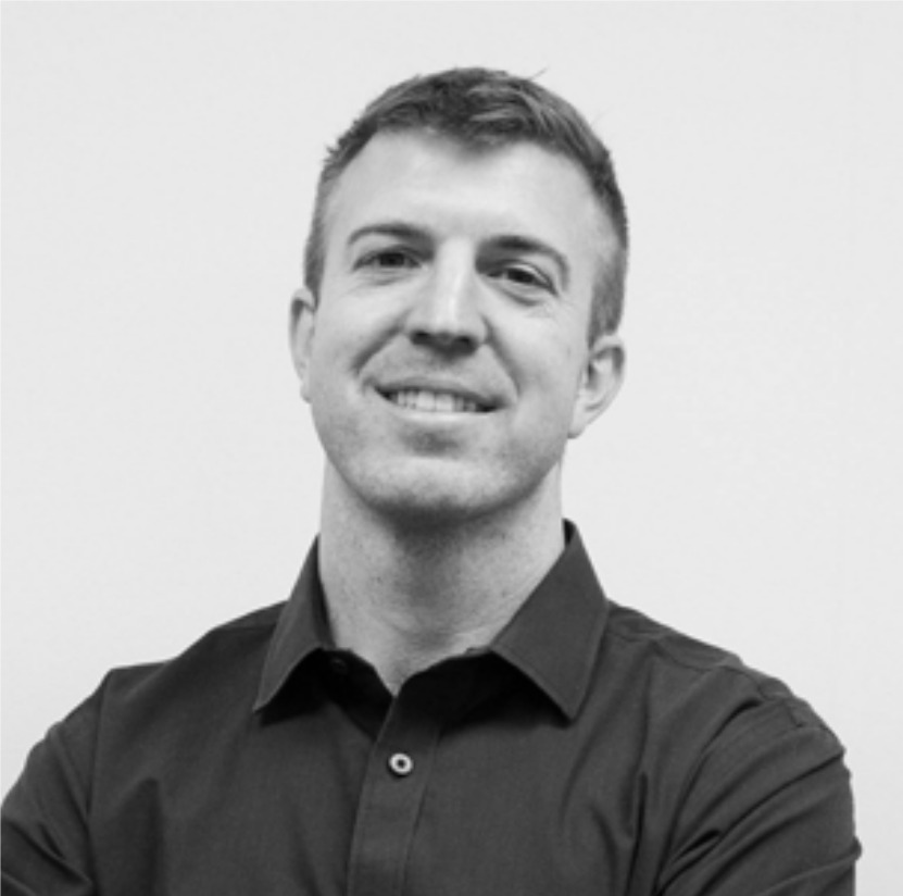 Smiling person with arms crossed in black shirt.