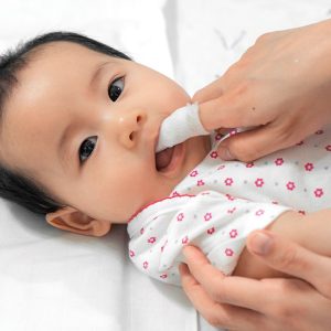 Baby's mouth gently cleaned with soft cloth.