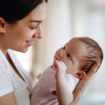 women-baby Smiling woman cradling a baby lovingly.